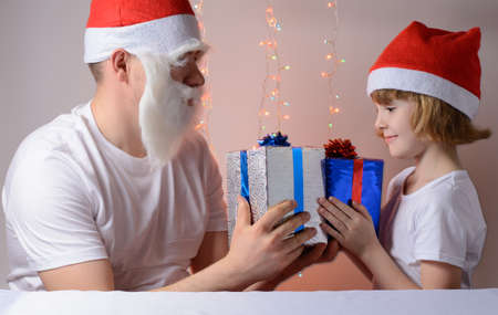 Little girl and father in Santa hats Christmas gift packsの写真素材