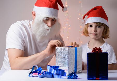 Little girl and father in Santa hats Christmas gift packsの写真素材