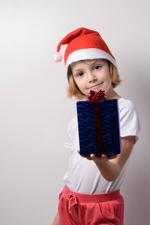 Little girl in santa hat with Christmas giftsの写真素材