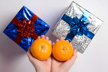 Two tangerine and Christmas gifts on a white backgroundの写真素材