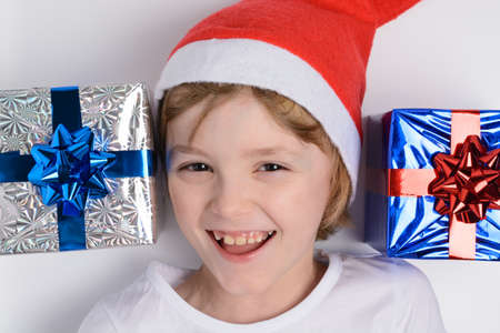 Little girl in santa hat with Christmas giftsの写真素材