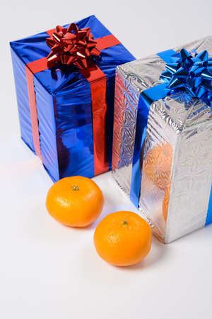 Two tangerine and Christmas gifts on a white backgroundの写真素材