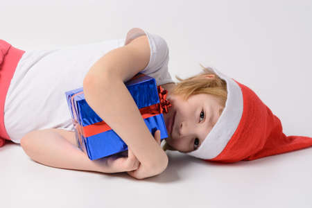 Little girl in santa hat with Christmas giftsの写真素材