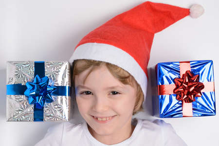 Little girl in santa hat with Christmas giftsの写真素材