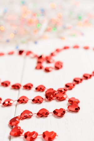 The figure in the shape of a heart made of red string on the wooden tableの写真素材