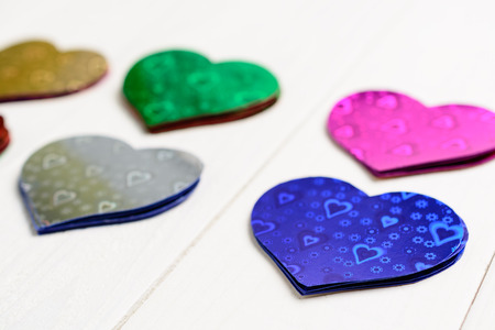 Figures from colored paper in the form of heart on the wooden table