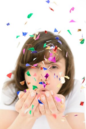 Young woman blows colorful confetti from his handsの写真素材