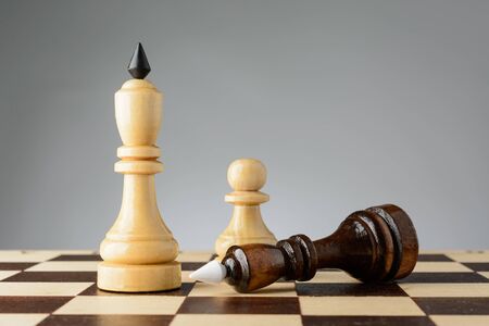 The black king is in front of a white king on a chessboardの写真素材