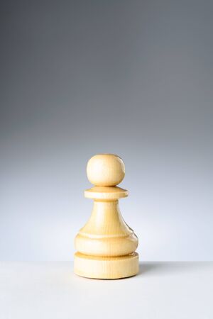White pawn on white table on gradient backgroundの写真素材