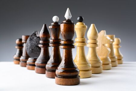 Black and white chess pieces on a white table on the gradient backgroundの写真素材