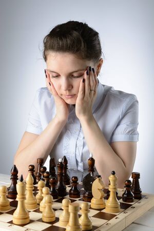 Business woman in a light blue shirt, playing chessの写真素材