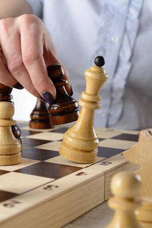 Business woman in a light blue shirt, playing chessの写真素材