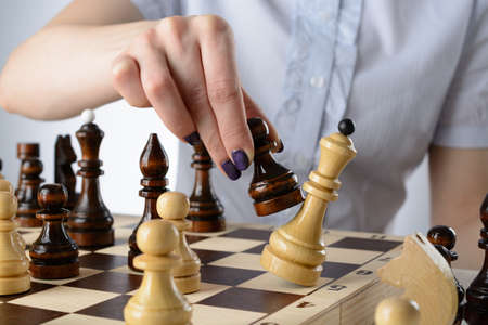 Business woman in a light blue shirt, playing chessの写真素材