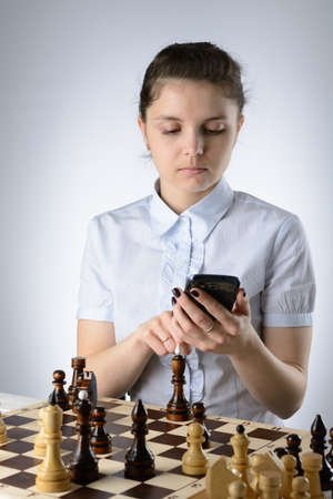 Business woman in a light blue shirt, playing chessの写真素材