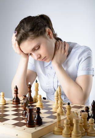 Business woman in a light blue shirt, playing chessの写真素材