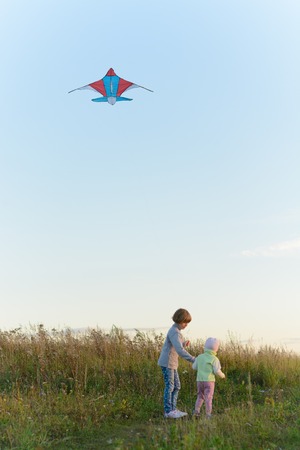Girls playing with a kite in the springの写真素材