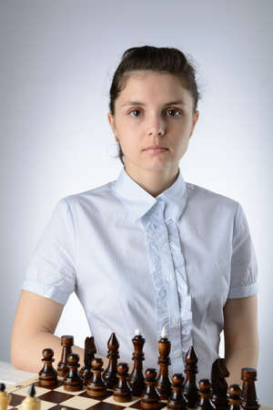 Business woman in a light blue shirt, playing chessの写真素材
