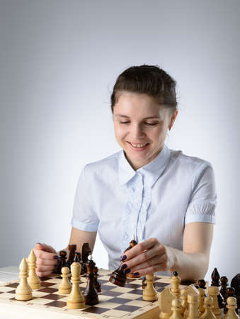 Business woman in a light blue shirt, playing chessの写真素材