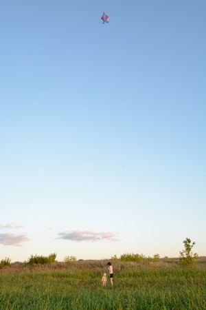 Girls playing with a kite in the springの写真素材