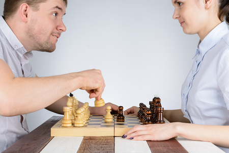Man playing chess against girls in and makes a move the white figureの写真素材