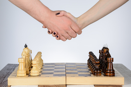 Male and female hand over a chess tableの写真素材