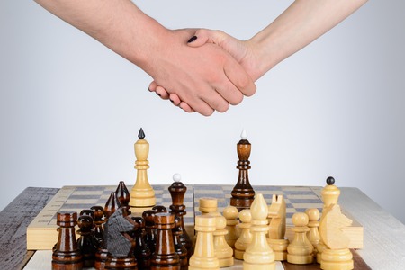 Male and female hand over a chess tableの写真素材