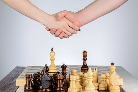 Male and female hand over a chess tableの写真素材