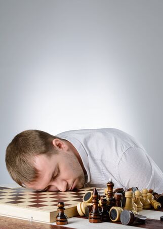 The man put his head on a chess board, and closed his eyesの写真素材