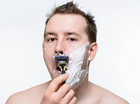 Man shaves shaving foam on a white backgroundの写真素材