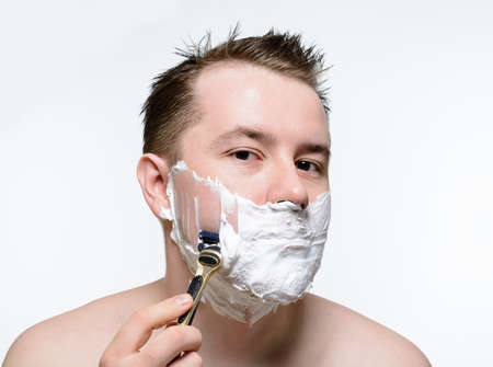 Man shaves shaving foam on a white backgroundの写真素材