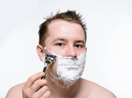 Man shaves shaving foam on a white backgroundの写真素材