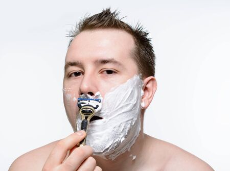 Man shaves shaving foam on a white backgroundの写真素材