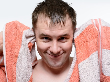 Naked man wipes his head in orange towelの写真素材
