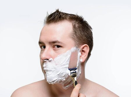 Man shaves shaving foam on a white backgroundの写真素材