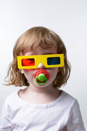 A small child in the 3D glasses on a white backgroundの写真素材