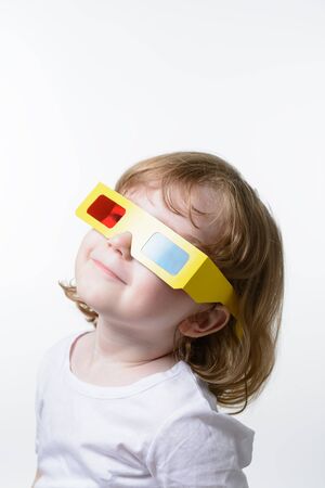 A small child in the 3D glasses on a white backgroundの写真素材