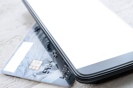 Credit card and smartphone lying on a white wooden tableの写真素材