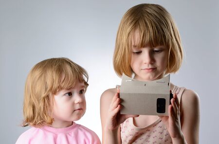 Two little girls are playing with virtual reality glassesの写真素材