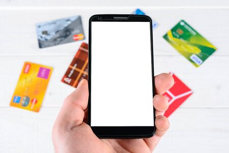 Man's hand holding a smart phone and credit card pay onlineの写真素材