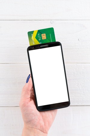 A woman holds a smartphone and pay for goods in the online storeの写真素材