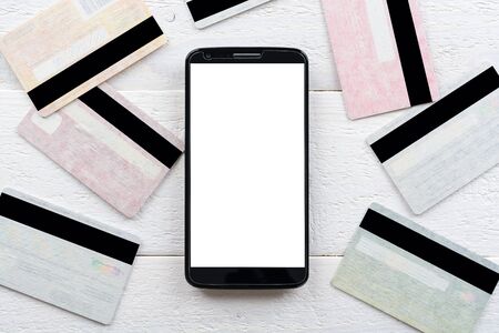 Credit cards and smartphone lying on a white wooden tableの写真素材