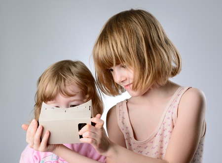 Two little girls are playing with virtual reality glassesの写真素材
