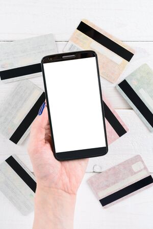A woman holds a smartphone and pay for goods in the online storeの写真素材