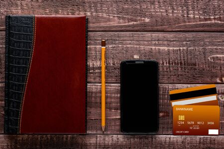 Top view of a brown wooden table with accessories for online shopping and paymentの写真素材