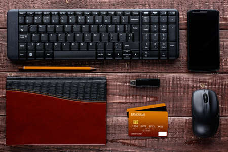 Top view of a brown wooden table with accessories for online shopping and paymentの写真素材
