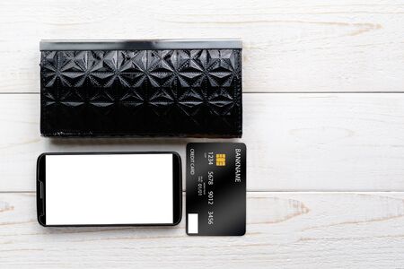 Smartphone, notebook and credit card on a white wooden tableの写真素材