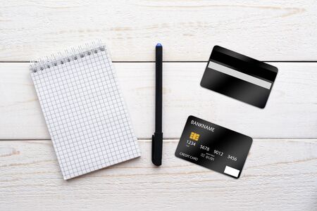 Notebook, pen and credit card on a white wooden tableの写真素材