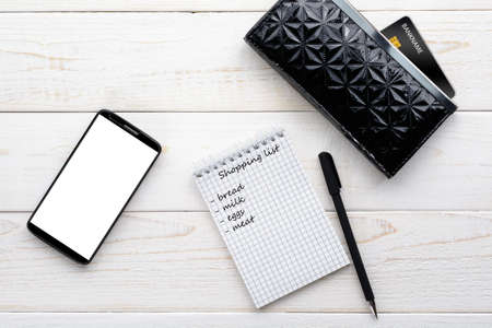 Smartphone, notebook, pen and credit card on a white wooden tableの写真素材