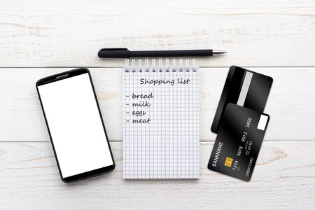 Smartphone, notebook, pen and credit card on a white wooden tableの写真素材