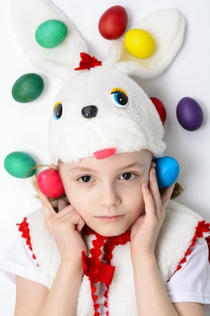 Girl in a bunny suit with Easter eggs on a white background
